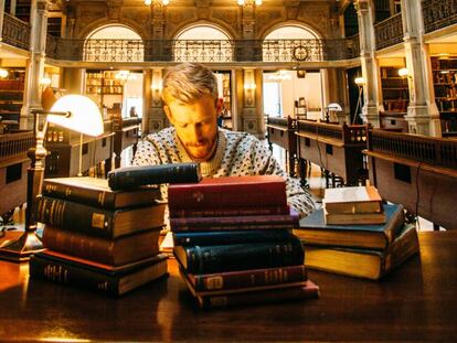 Un hombre estudia en una biblioteca.