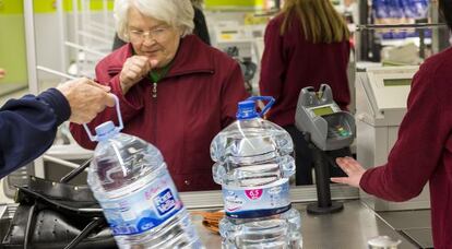 Una mujer compra agua embotellada en Alzira.