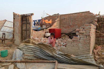 "Los helicópteros están preparados para intervenir la mañana (del lunes) para proceder a las operaciones de rescate", indicó el primer ministro. En la imagen, una niña nepalesa se encuentra sentada en una de las casas destruidas por la tormenta en el pueblo de Bhaluhi Bharbaliya (Nepal).