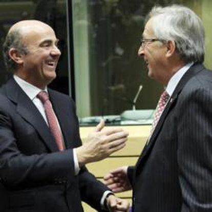 El ministro de Economía y Competitividad, Luis de Guindos, conversa con el presidente del Eurogrupo, Jean-Claude Juncker, y con el ministro de Finanzas galo, François Baroin