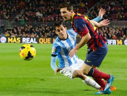Messi se escapa de un jugador del Málaga.