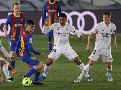 Pedri retiene el balón ante Casemiro y Kroos.