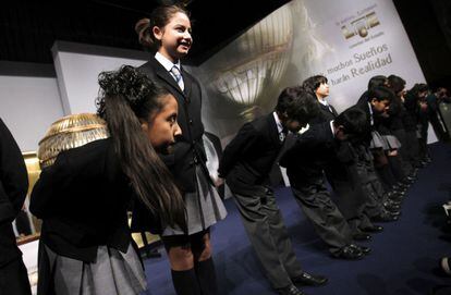 Los niños del colegio de San Ildefonso saludan en el salón del Palacio de Congresos.