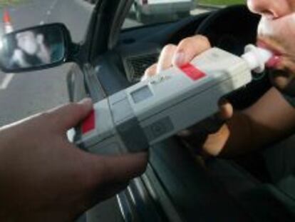 Una conductor realiza un control del alcoholemia en carretera.