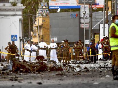 Unos sacerdotes observan los restos de una furgoneta bomba hoy lunes en Colombo (Sri Lanka). / En vídeo: nuevas imágenes del atentado de Sri Lanka.