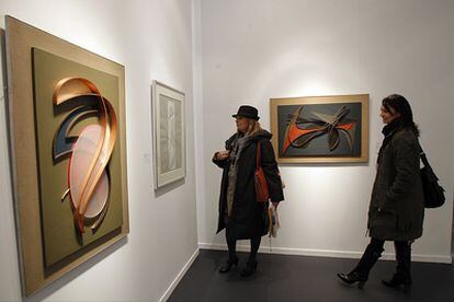 Dos visitantes de Arco en el 'stand' de la galería Oriol contemplan obra de César Domela