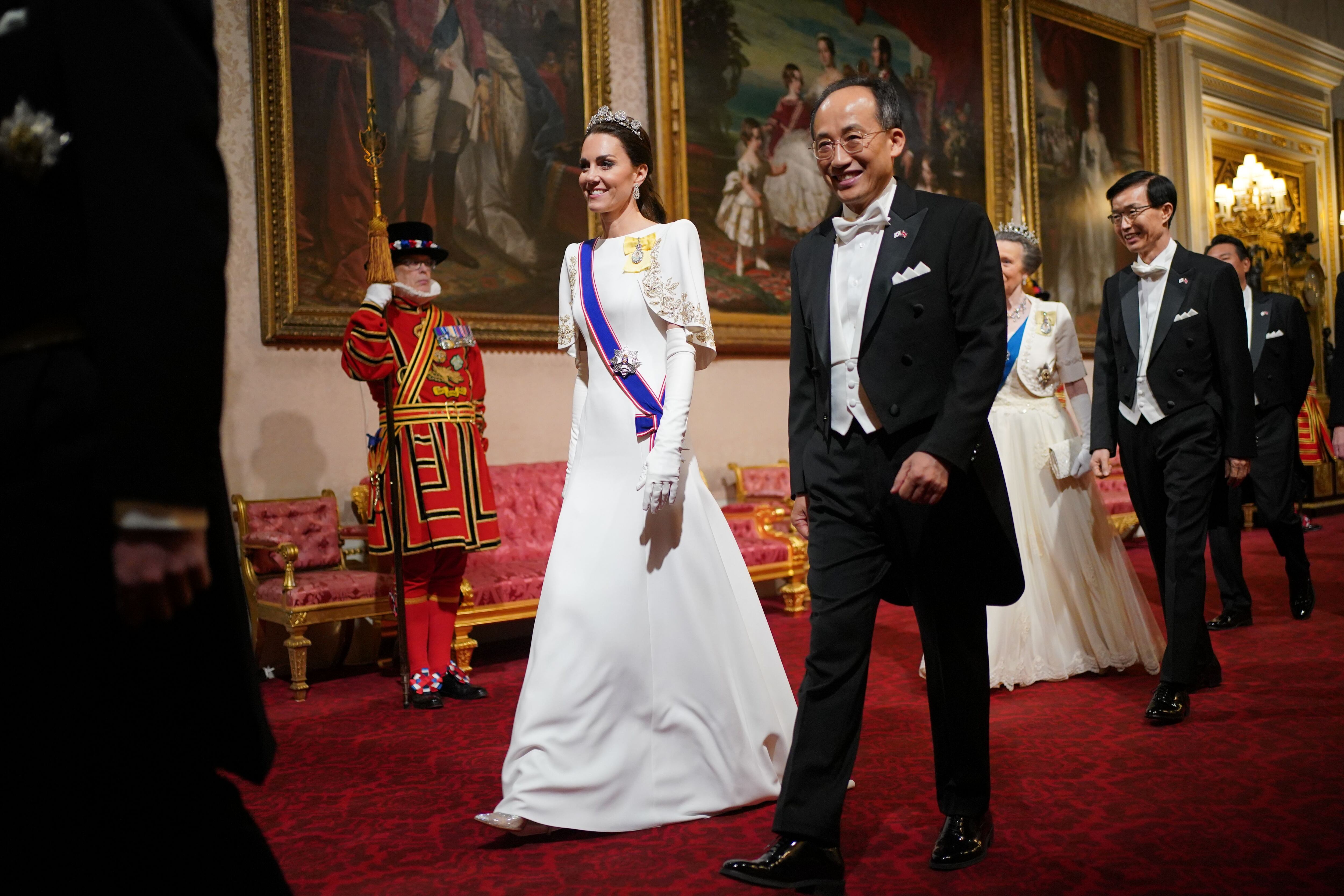 Kate Middleton, acompañada del vicepresidente de Corea del Sur, Choo Kyung-ho, seguida de la princesa Anna, a su entrada al banquete ofrecido en el palacio de Buckingham, el 21 de noviembre.
