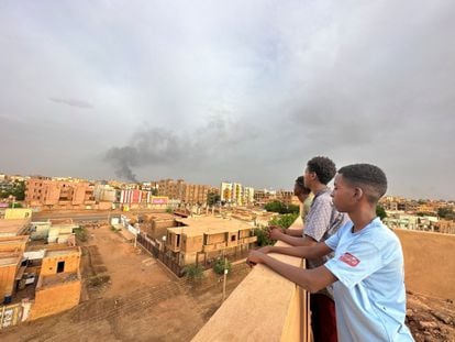 Varias personas obervan el humo de los combates en la ciudad sudanesa de Omdurman.
