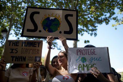 Varias jóvenes portan carteles contra el cambio climático en Sevilla.