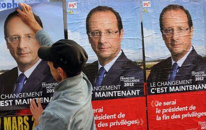 Un hombre coloca afiches electorales del candidato del partido socialista franc&eacute;s, Fran&ccedil;ois Hollande en Burdeos.