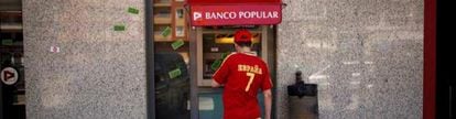 Una persona saca dinero de un cajero de Banco Popular