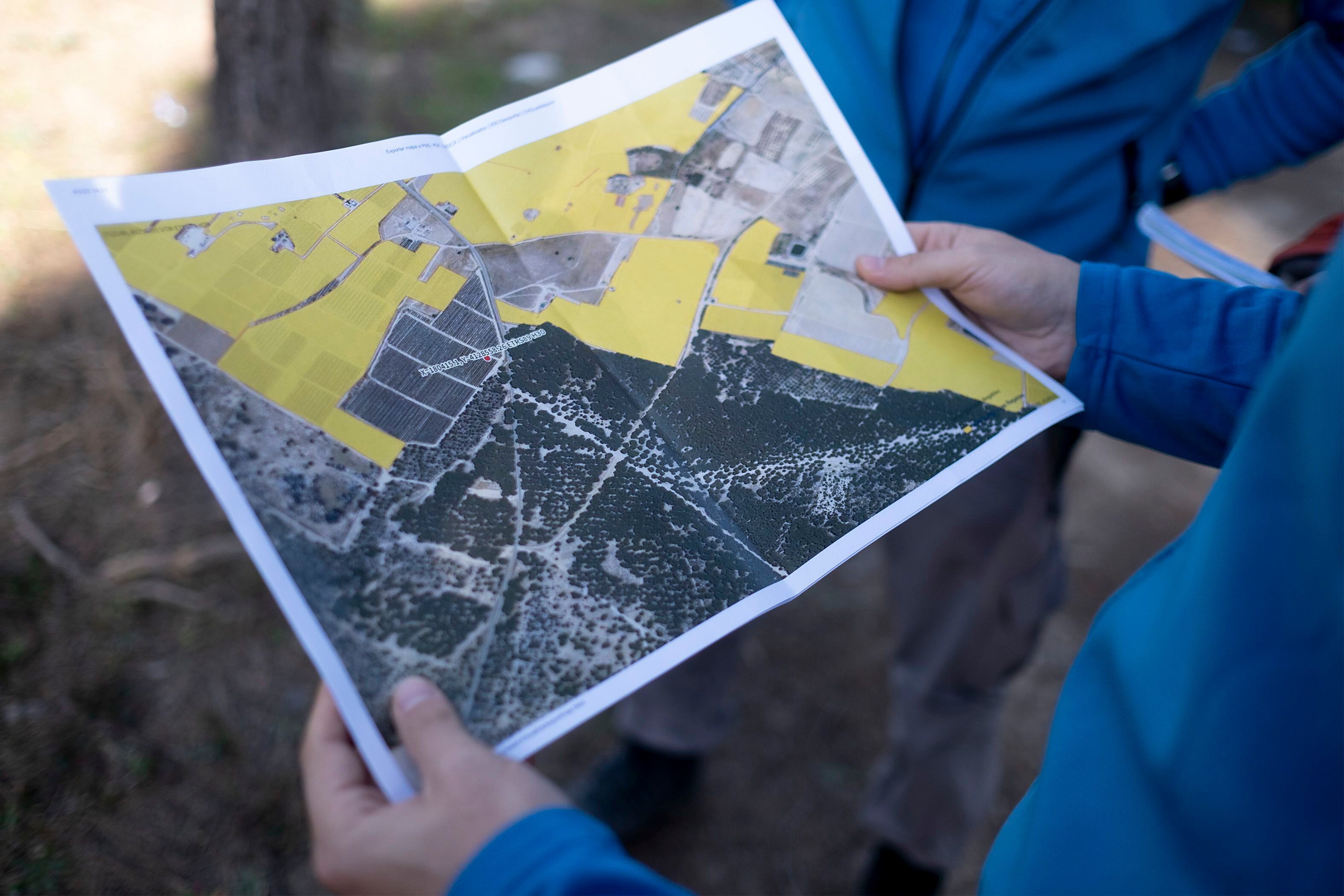 Un agente sostiene un mapa con invernaderos fuera de la zona legal, coloreada de amarillo. 