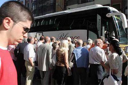 Varios manifestantes se disponen a subir a autocares en Bilbao para desplazarse a Madrid.