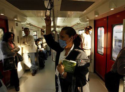 Una mujer viaja en un tren de Ciudad de México ataviada con mascarilla por el brote del extraño virus de gripe que afecta al país.