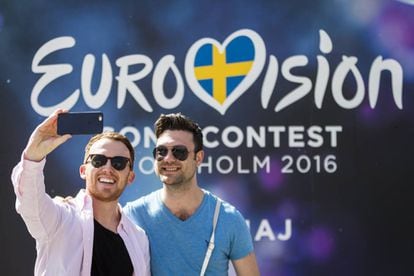 Dos seguidores de Eurovisión se hacen una foto ante un cartel en Estocolmo.