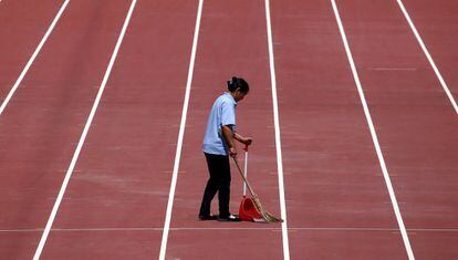 Un operario recoge este jueves la basura del antiguo estadio olímpico, conocido como El Nido, de Pekín.