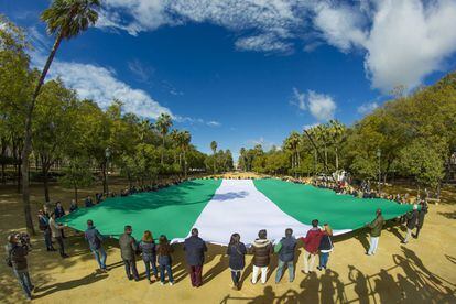 Militantes del PP despliegan la mayor bandera andaluza en Sevilla.