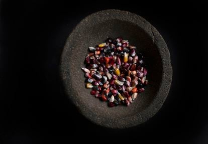 Molcajete de piedra con granos de maíz. El molcajete, término de raíz náhuatl, es un mortero que se emplea para preparar salsas.