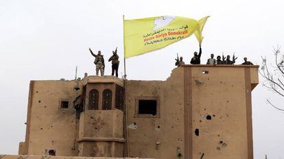 Combatientes de las Fuerzas Democráticas Sirias (FDS) ondean una bandera en Baguz,Siria. 