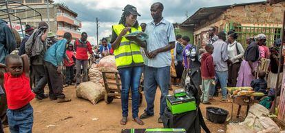 Una representante de ventas de la empresa M-Kopa habla con un usuario del servicio de energ&iacute;a solar en Kenia.