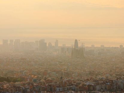 Vista aérea de Barcelona, con la Sagrada Familia y la Torre Agbar en el centro, apenas visibles por la contaminación atmosférica.
