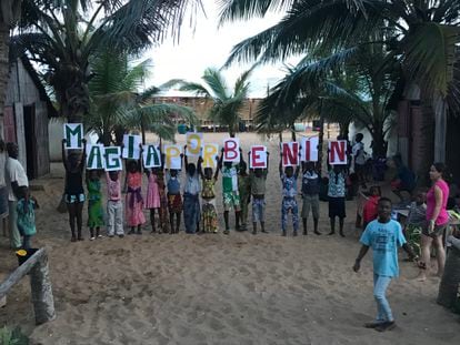 Los niños del centro de Mensajeros por la Paz, posan con un cartel de ‘Magia por Benín’, en Cotonou (Benín).