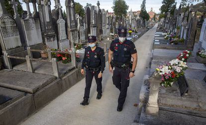 Una pareja de la Ertzaina en el cementerio de Polloe de San Sebastián, este domingo.