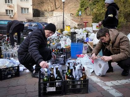 MIembros de la defensa civil preparan cócteles molotov en una calle de Kiev, este domingo.