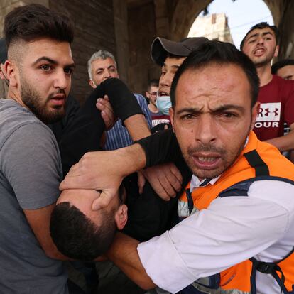 Palestinian medics evacuate a wounded protester amid clashes with Israeli security forces in Jerusalem's Old City on May 10, 2021, as a planned march marking Israel's 1967 takeover of the holy city threatened to further inflame tensions. (Photo by EMMANUEL DUNAND / AFP)