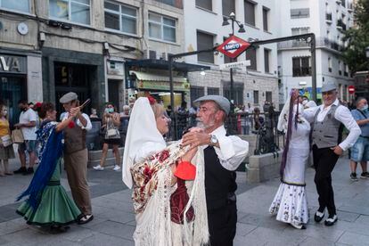 Baile de chulapos en la salida de la boca de metro de Lavapiés, en Madrid, durante las fiestas del barrio.
