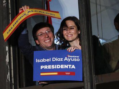Martínez-Almeida y Díaz Ayuso celebrando su éxito desde una ventana de la sede del PP en la calle Génova.