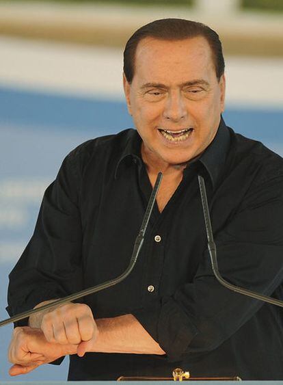 Silvio Berlusconi cruza los brazos como si estuviera esposado, en un acto de su partido el pasado domingo.
