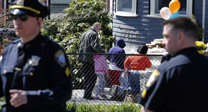 Un grupo de vecinos acude a rezar ante la casa de la familia Richard, en Dorchester, Boston.