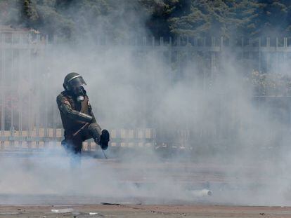 Un miembro de las fuerzas de seguridad chilenas golpea un bote de gas este viernes.