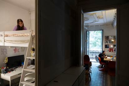 Claudia Schneider y su hija Tiziana, este julio en su apartamento del Eixample en Barcelona. Mientras la madre trabaja, la hija lee un libro. 