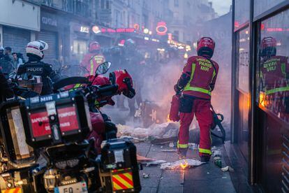 Los bomberos apagan una barricada incendiada durante los disturbios en París.