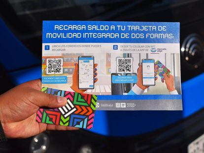 Un usuario del Servicio de Transportes Eléctricos (STE) sostiene un panfleto que indica las opciones para recargar su Tarjeta de Movilidad Integrada, en Ciudad de México.