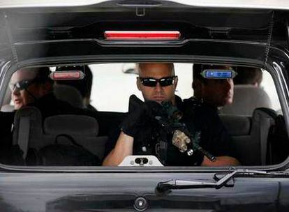 Miembros de los servicios secretos estadounidenses escoltan el coche de Barack Obama, situado detrás, en Chicago.