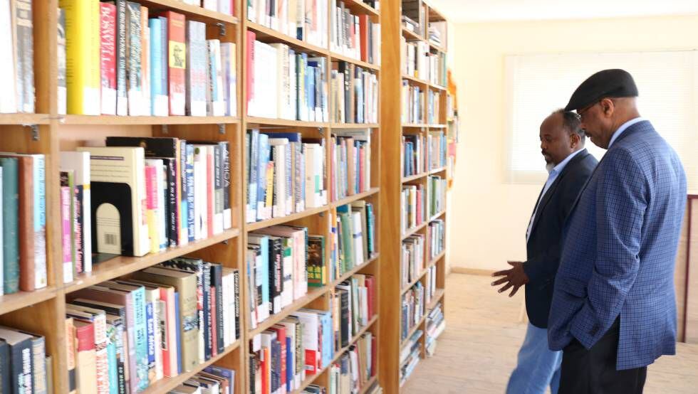 Dos usuarios contemplan los libros de la biblioteca del Centro Cultural Hargeysa.