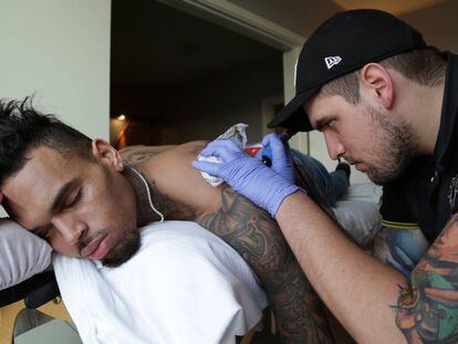 Fredy haciéndole un tatuaje al rapero Chis Brown