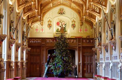 Miembros del Royal Collection Trust decoran el árbol de 6 metros de altura en el salón de San Jorge, en Windsor, tomado de uno de los parques de los alrededores, y vestido con cientos de luces y adornos.