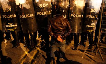 Un seguidor de Guillermo Lasso, frente a la polic&iacute;a ecuatoriana.