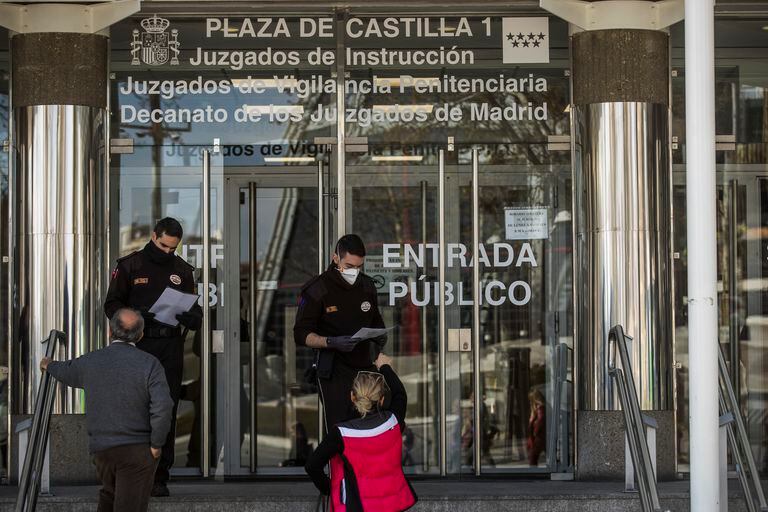 Dos guardias de seguridad de los juzgados de Plaza Castilla piden papeles a las personas que quieren entrar.
