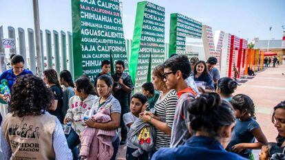 Migrantes centroamericanos deportados de EE UU esperan en el puesto fronterizo de El Chaparral a ser trasladados a un centro en Tijuana, el 22 de julio. 