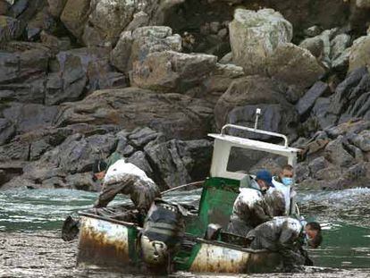 Marineros gallegos recogen fuel del <i>Prestige</i> en su barca junto a las islas Cíes.