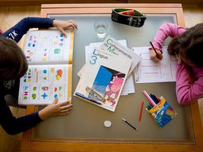 Dos niños hacen sus deberes escolares en gallego