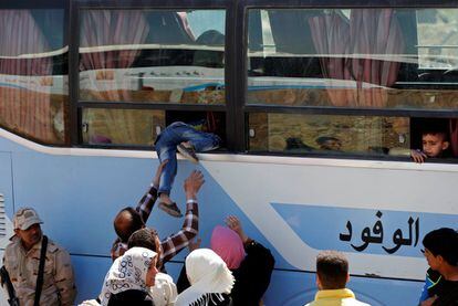 Un grupo de desplazados iraquíes, que se han visto obligados a abandonar sus hogares, suben a un autobús antes de ser trasladados al este de Mosul (Iraq).