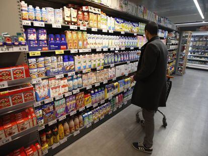 Un consumidor en la sección de lácteos de un supermercado.