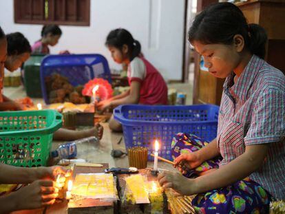 Niños elaborando cigarros en Myanmar.