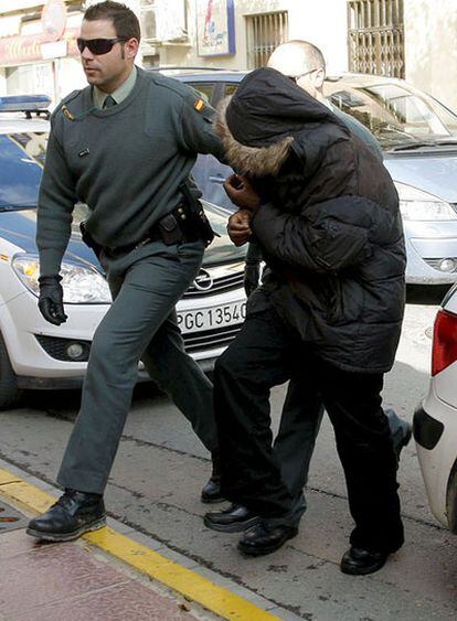 Uno de los cinco subsaharianos detenidos por los altercados en La Mojonera (Almería) es custodiado por agentes de la Guardia Civil a su llegada al Juzgado de Instrucción 1 de El Ejido.